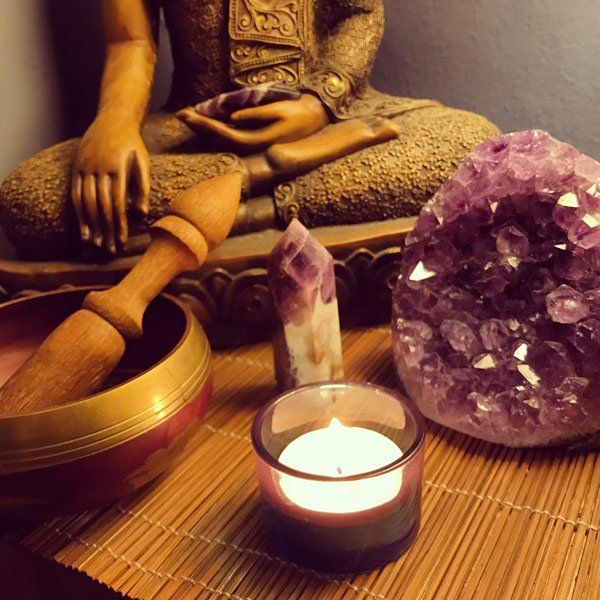 purple geode next to candle