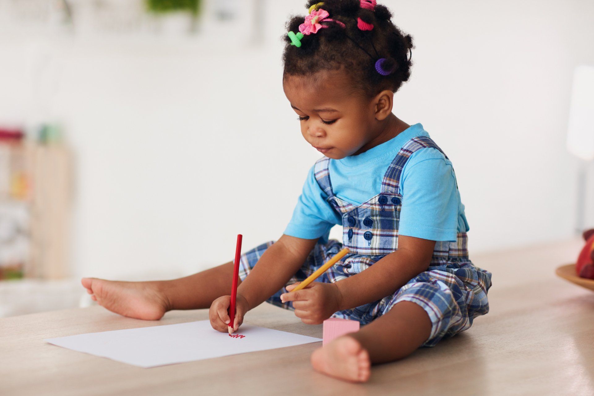 toddle girl sitting on floor and drawing