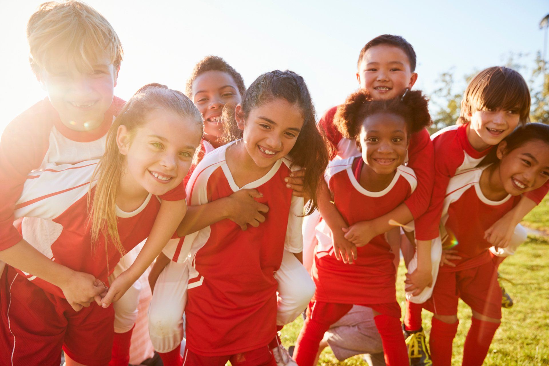 preteen co-ed soccer team in red uniforms