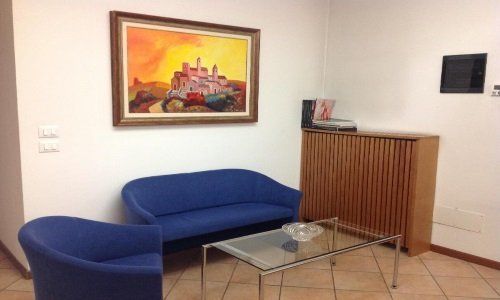 Sala d’attesa, due sofa blu,tavola bassa di vetro