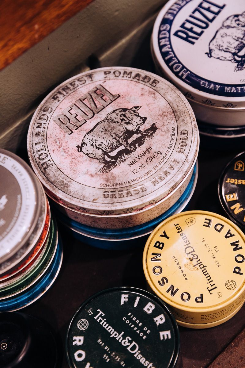 A variety of hair products are stacked on top of each other on a table.