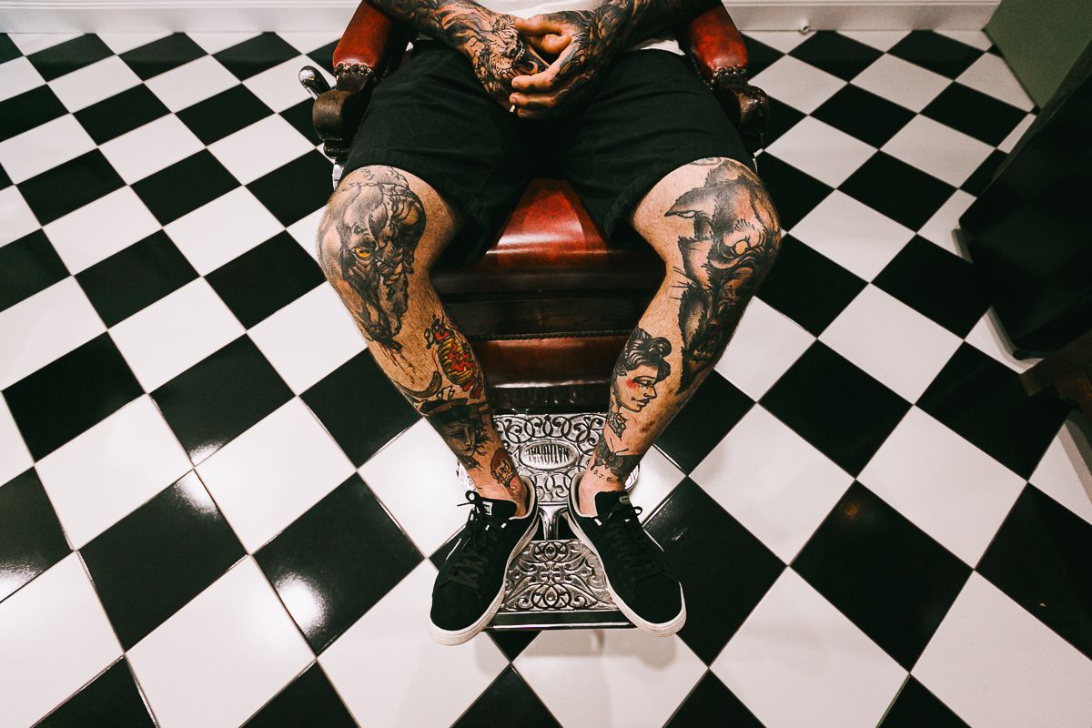 Man With Tattoo Sitting On A Chair — Bangalow Barber Shop in Bangalow NSW