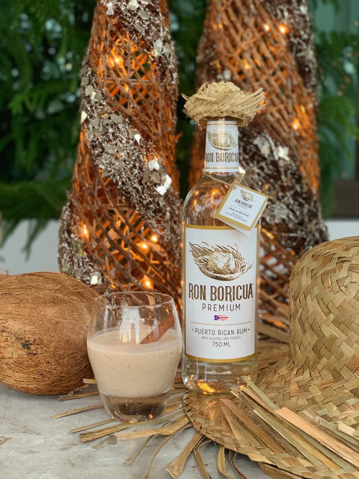 A bottle of Ron Boricua Premium next to a glass of Puerto Rican coquito drink.