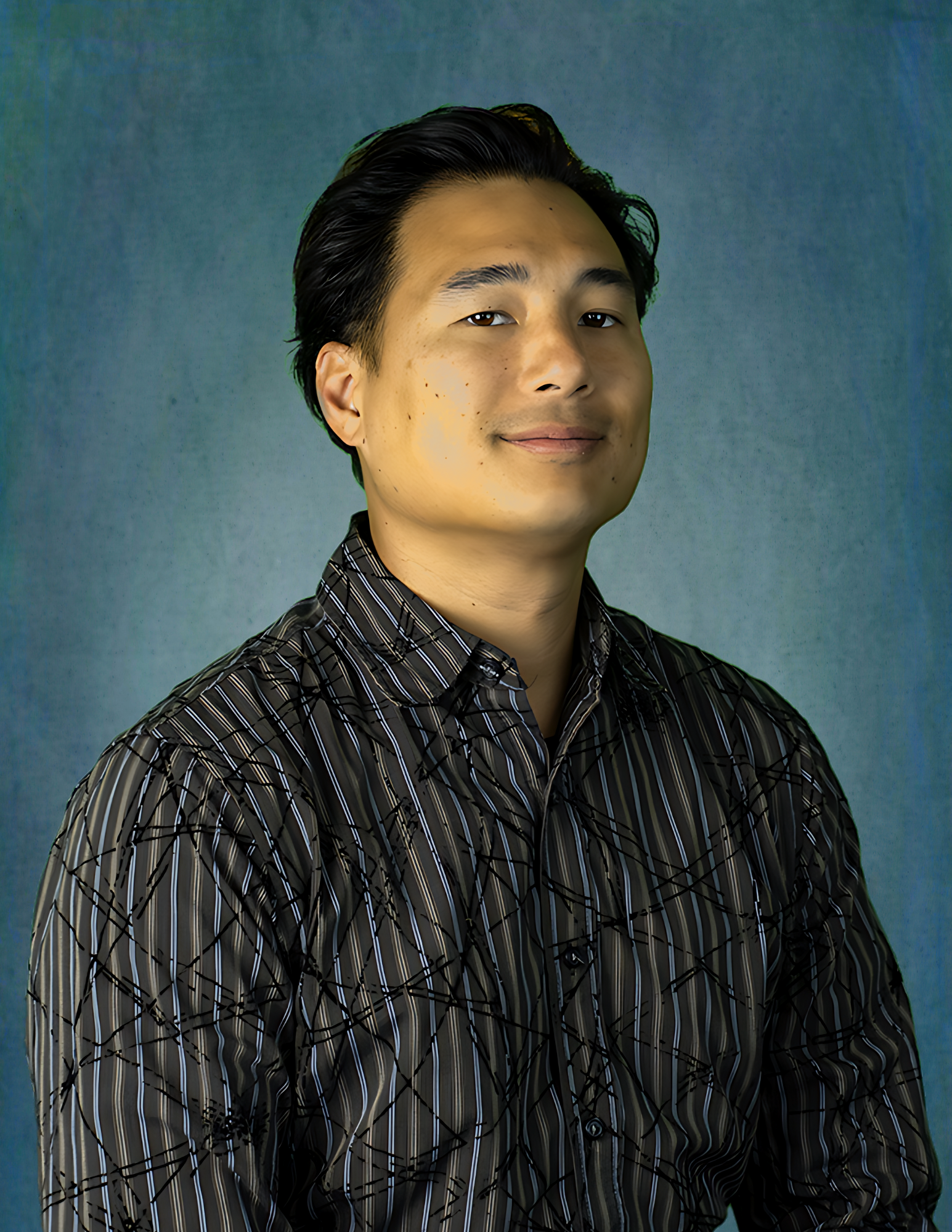 A man in a striped shirt stands in front of a blue background
