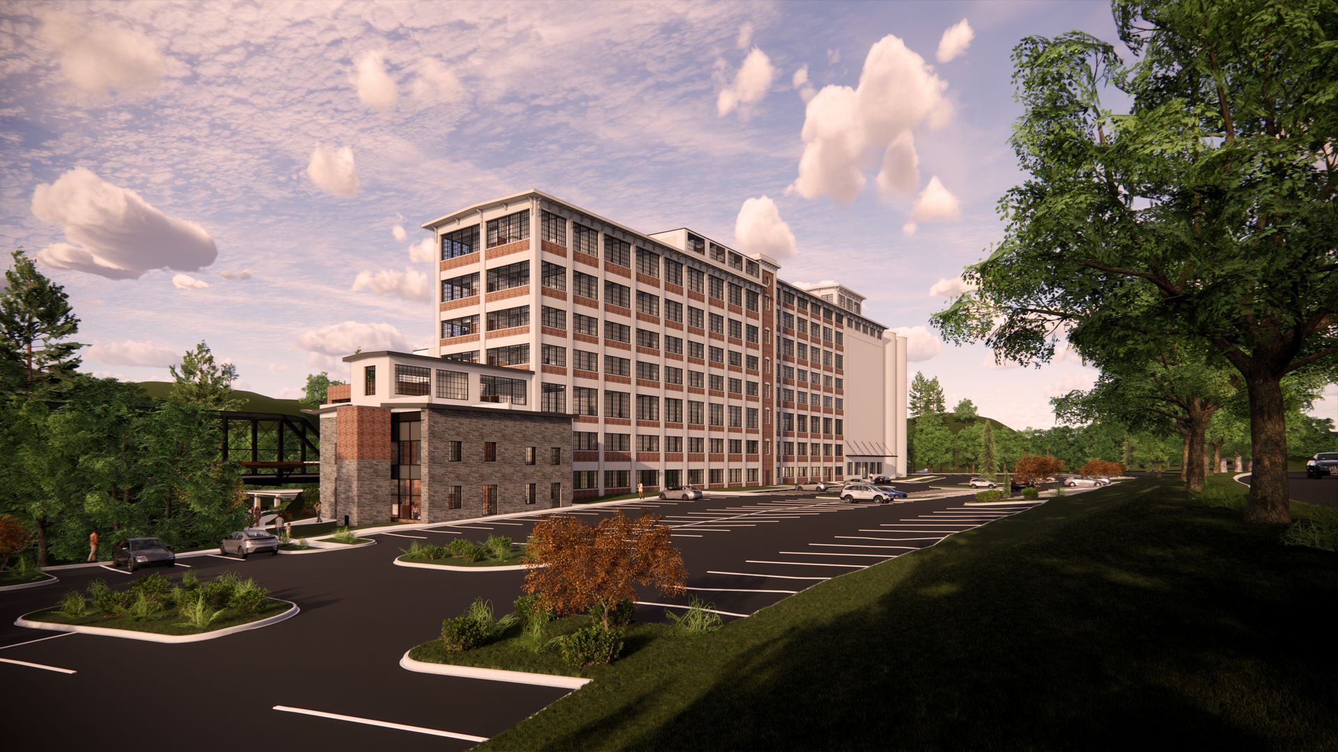 Modern multi-story office building beside a road, with trees, landscaping, and a pink evening sky.
