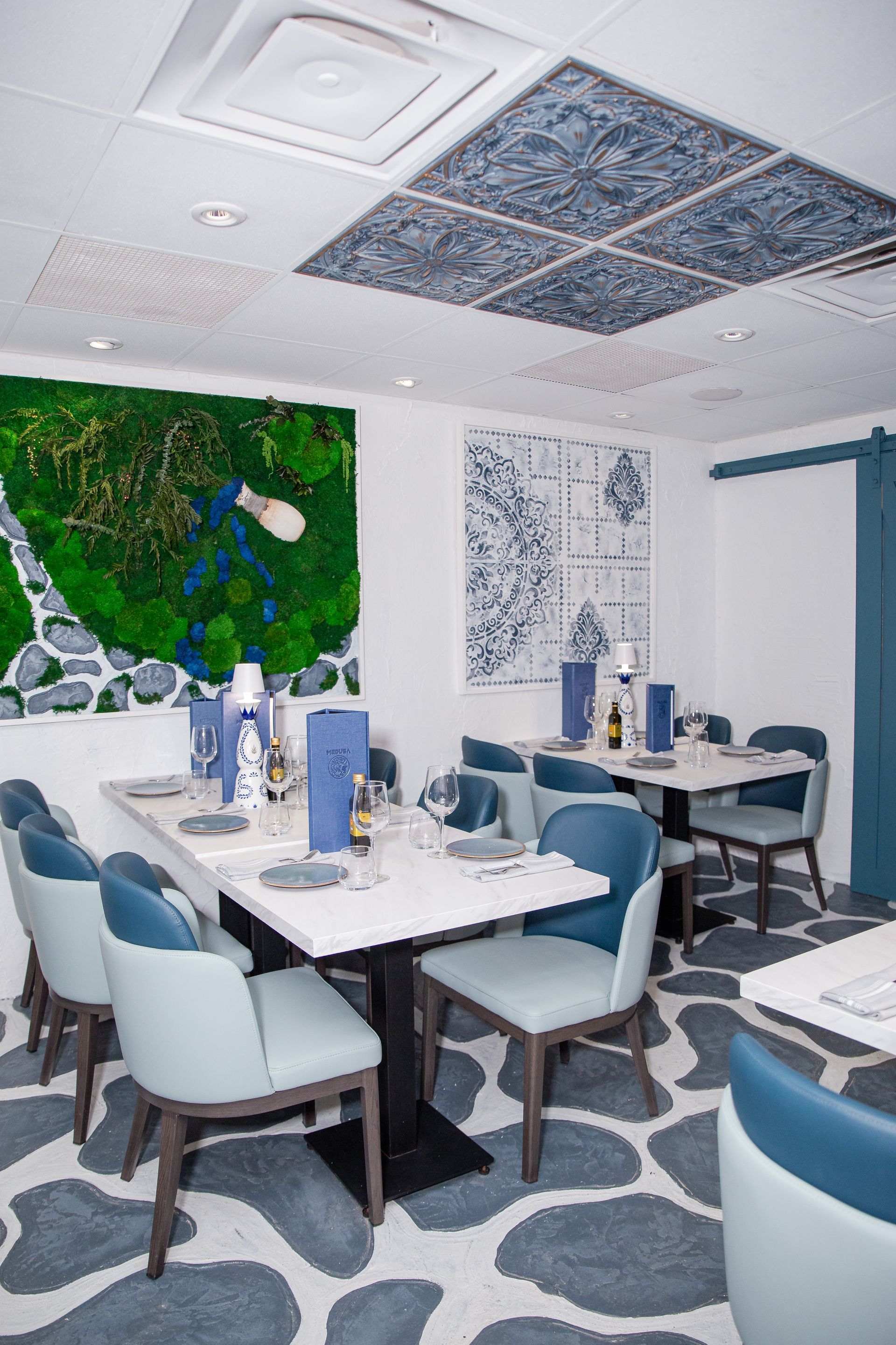 A restaurant with tables and chairs and a painting on the wall.