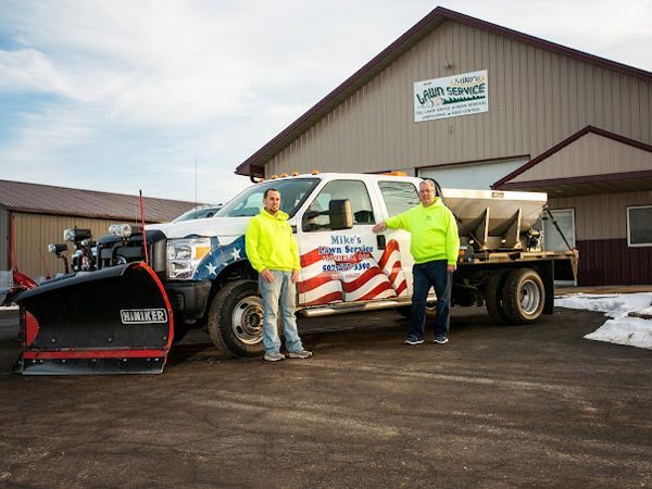 A lawn with a yellow sign in front of a blue house