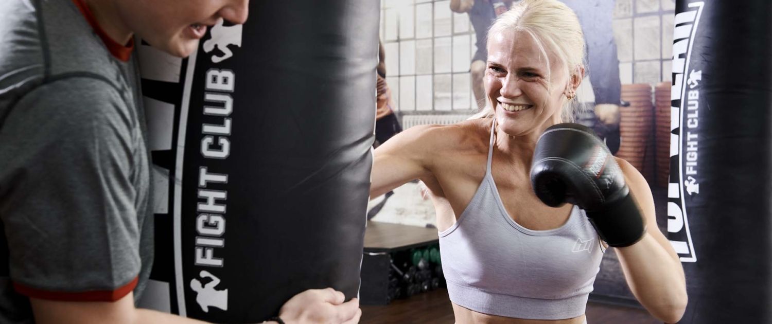 Et fitnesscenter fyldt med masser af håndvægte og bænke.