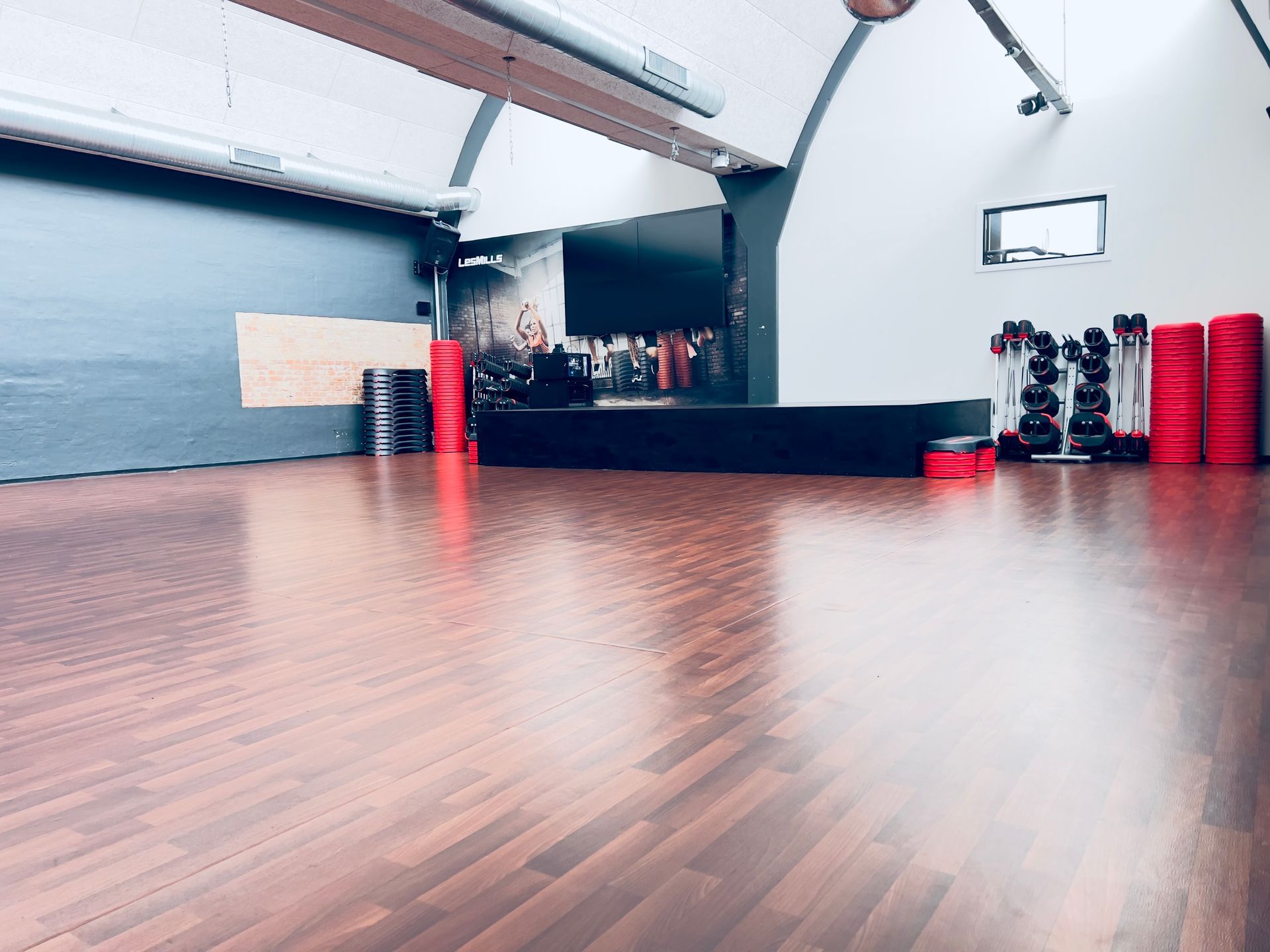 Et tomt dansestudie med et trægulv og et juletræ.