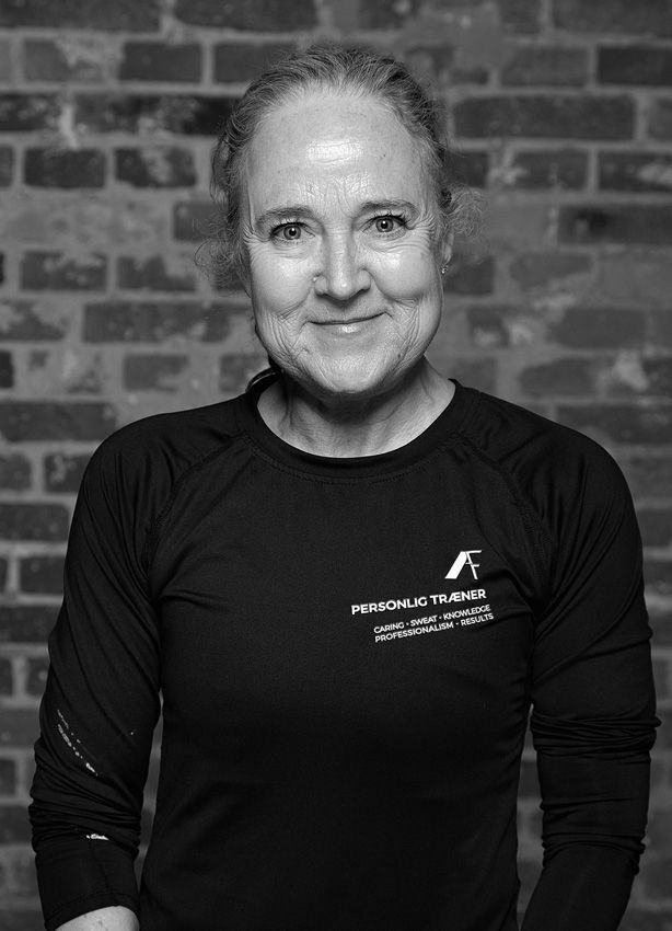 En kvinde står i et fitnesscenter iført en sweater med leopardprint.