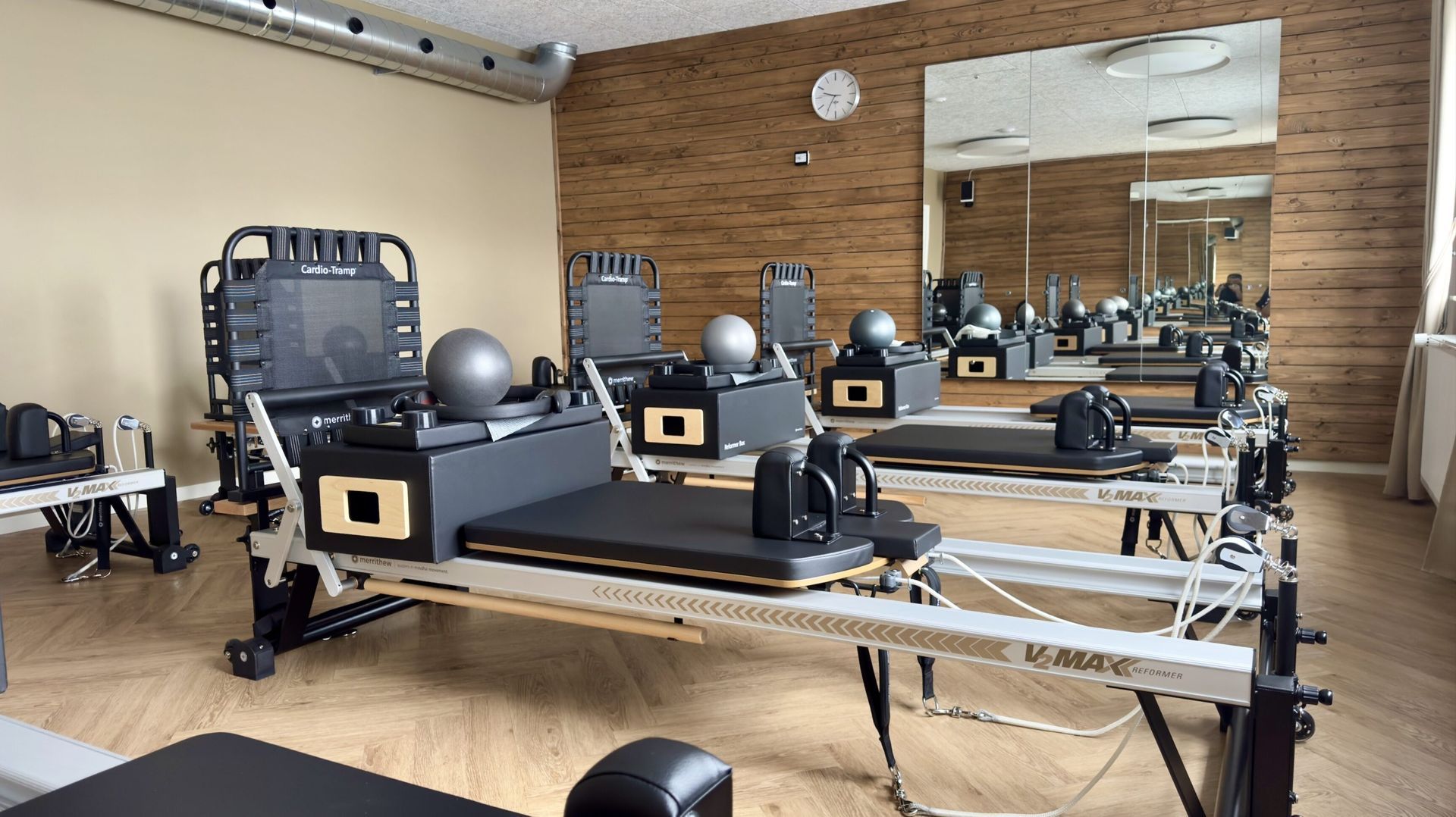 Et fitnesscenter fyldt med masser af træningsudstyr og en murstensvæg.