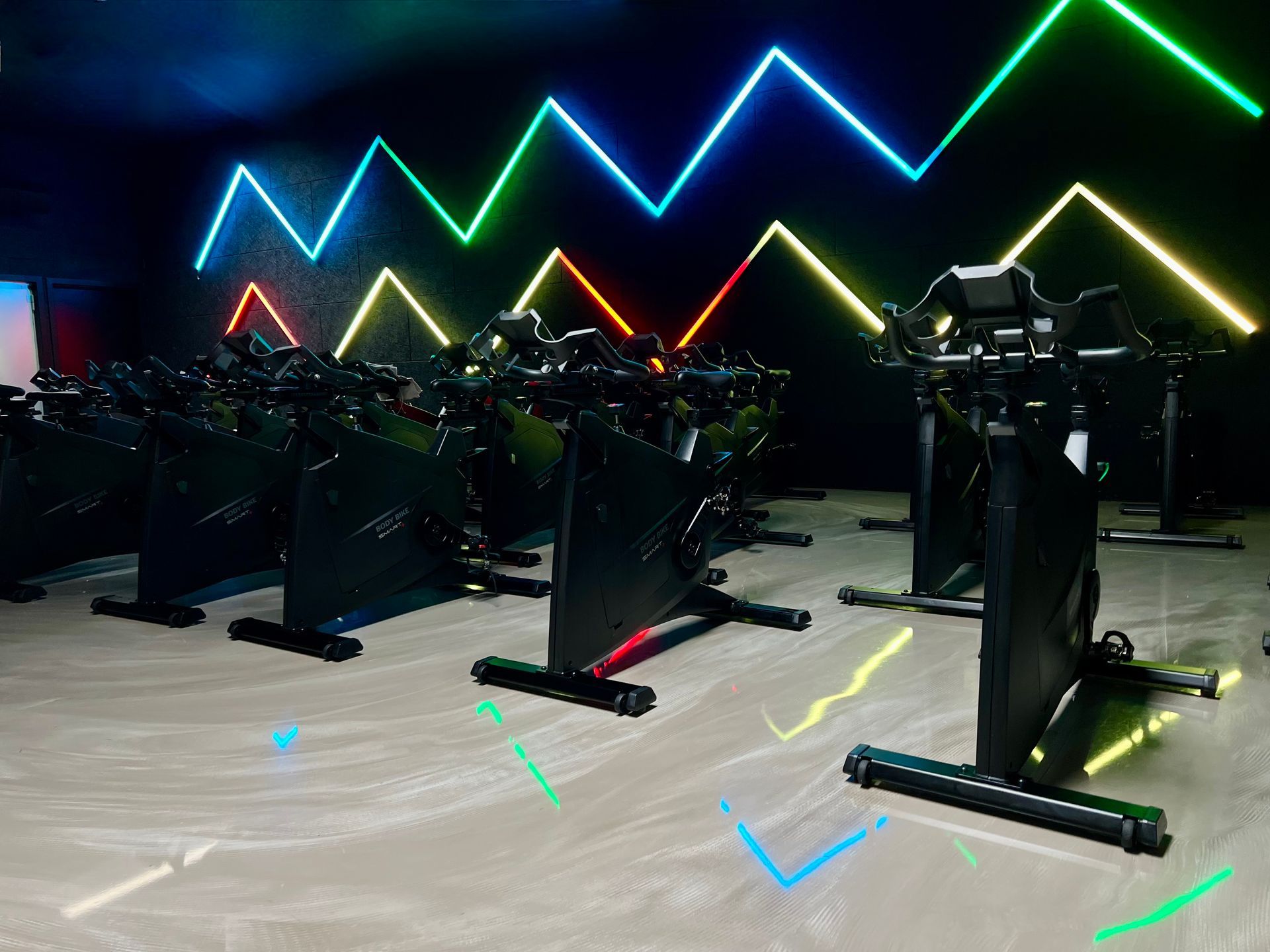 En række motionscykler står på række i et fitnesscenter.