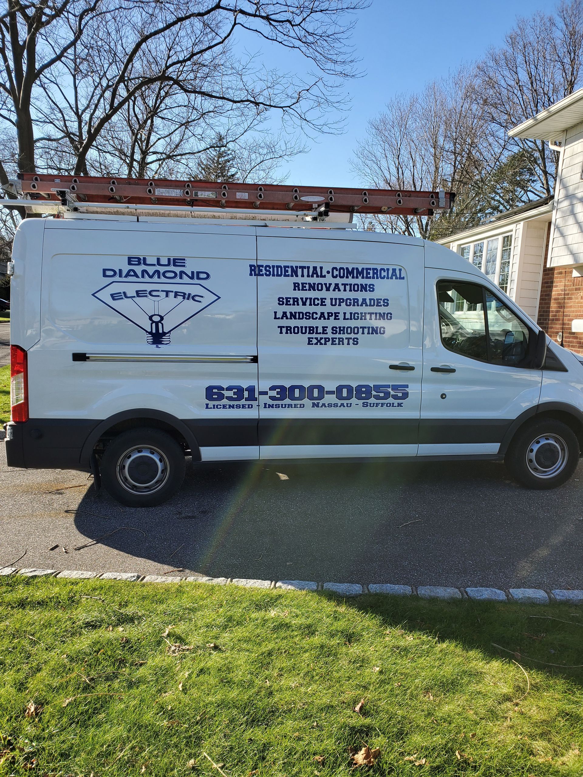 A white van is parked in a driveway next to a house.