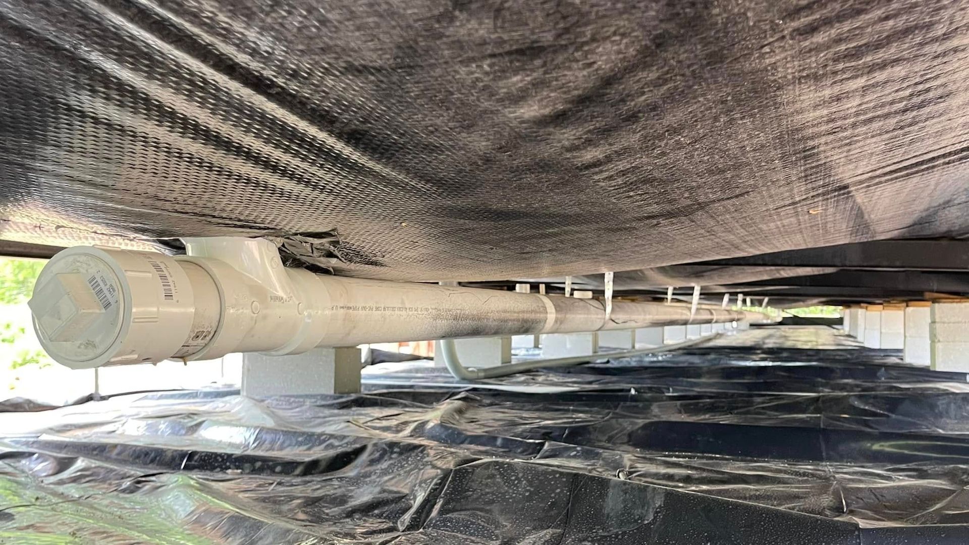 A white pipe is hanging from the ceiling of a building.