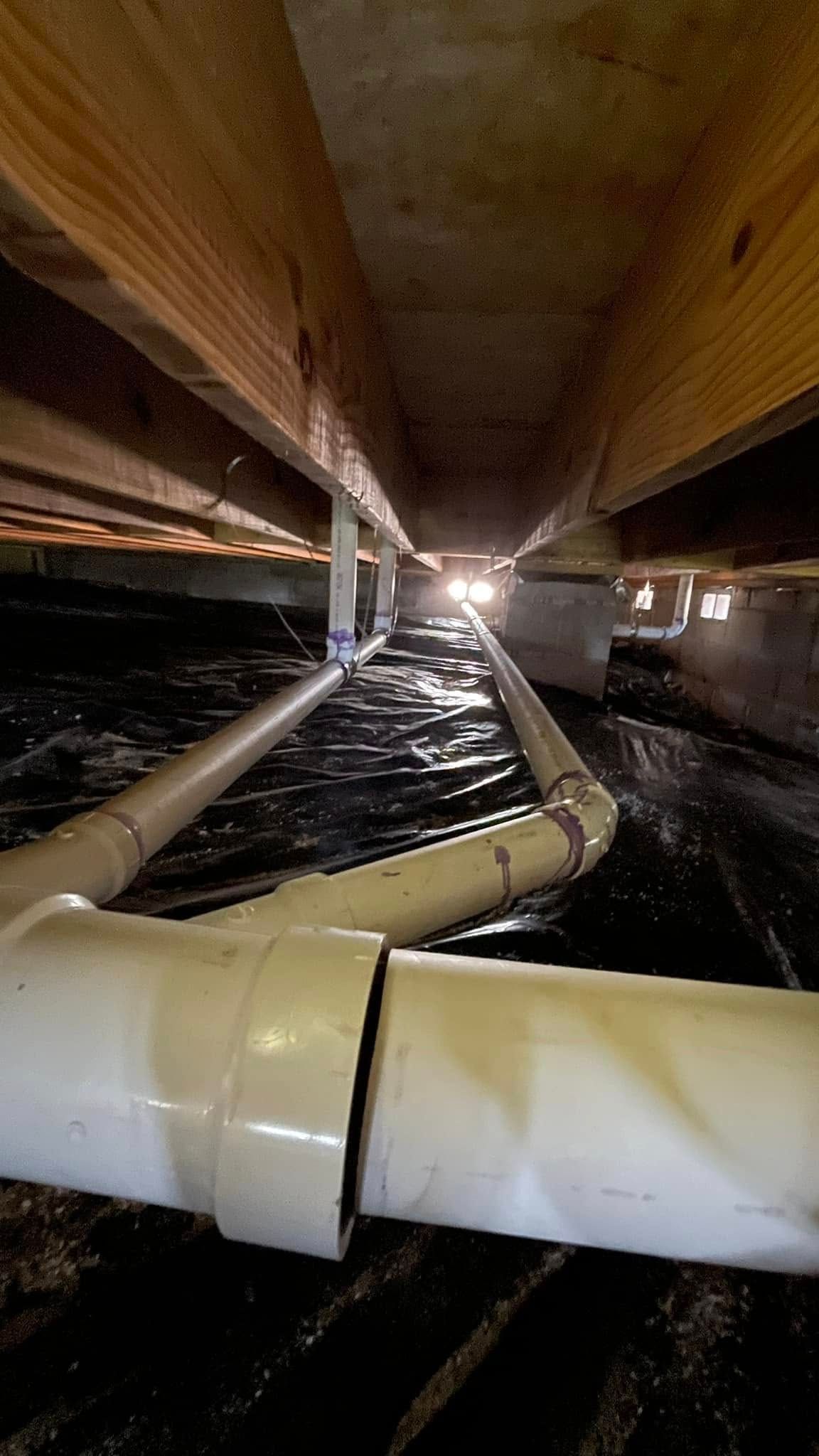 A close up of a drain pipe in a basement.