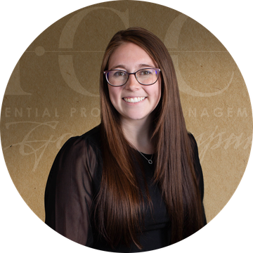 Woman with long brown hair and glasses smiling.