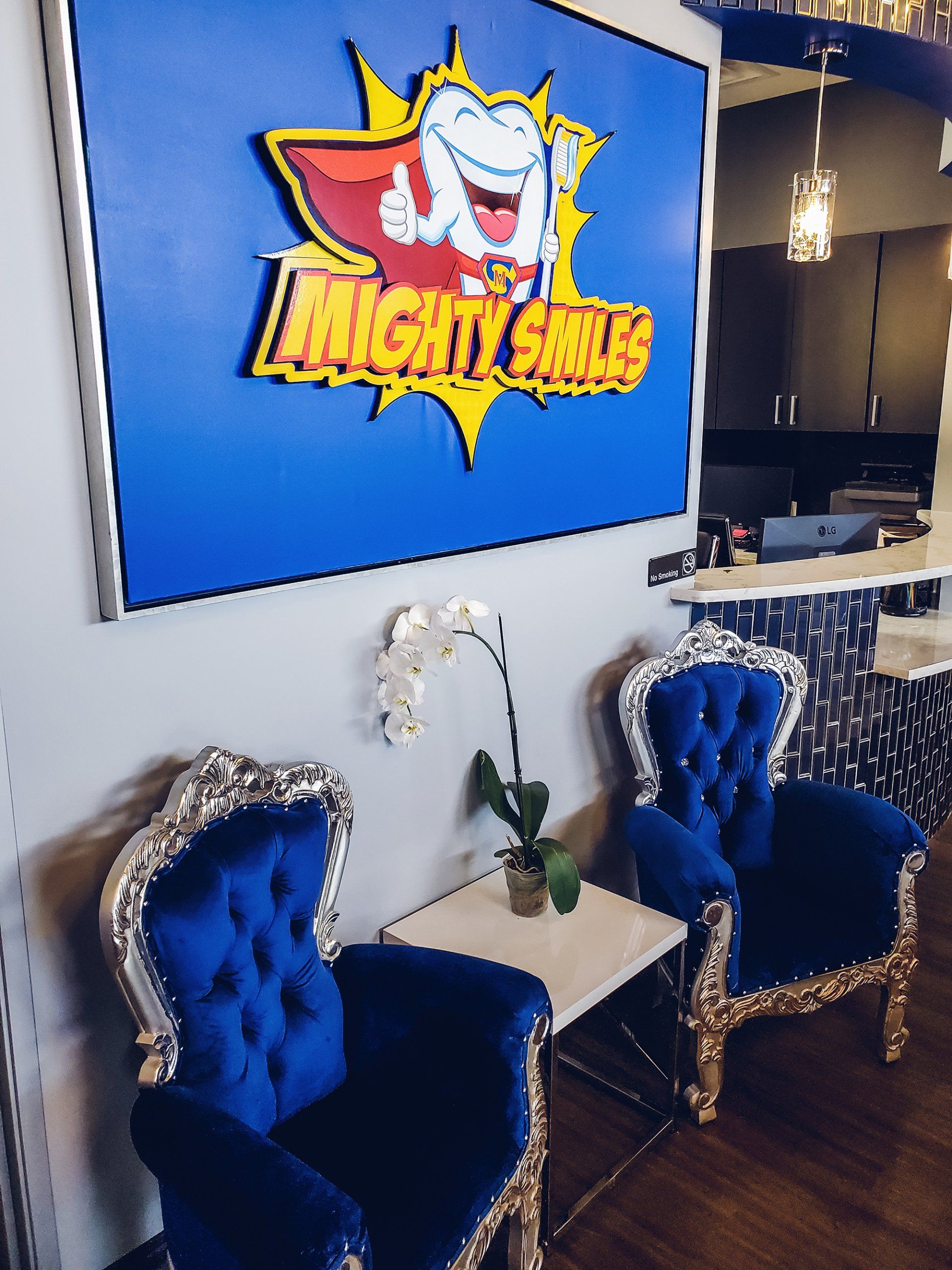 Mighty Smiles Dental, Dallas & Fort Worth. Lobby Two blue chairs in front of a sign that says mighty smiles