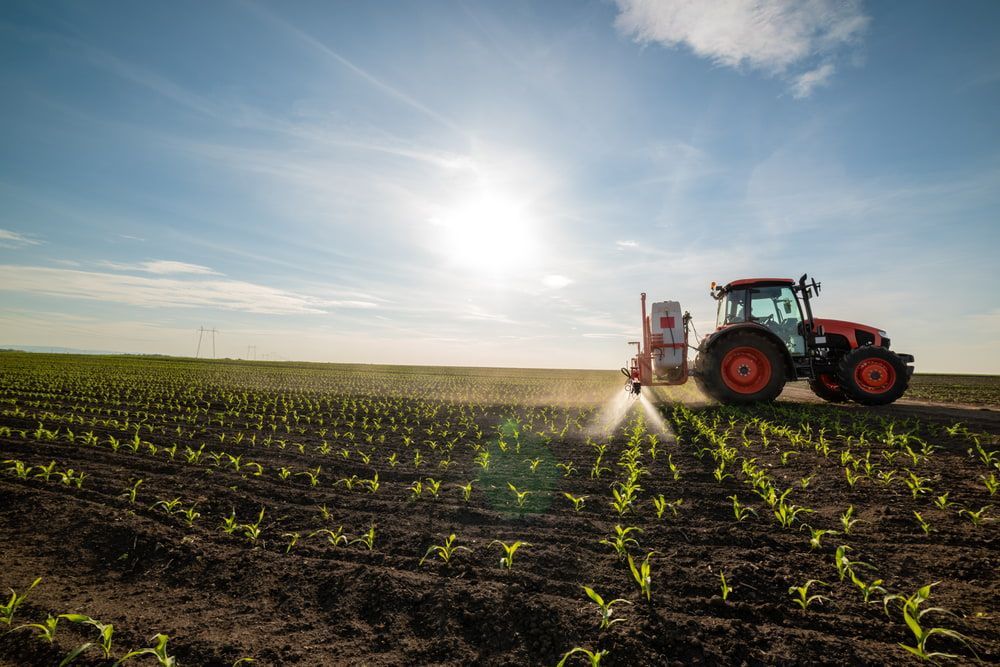 A Tractor Is Spraying Fertilizer on A Corn Field — Parkes Machinery Services PTY LTD in Parkes, NSW