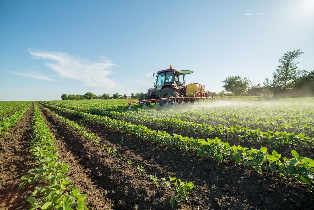 A Tractor Is Spraying Fertilizer on A Field of Plants — Parkes Machinery Services PTY LTD in Warren, NSW