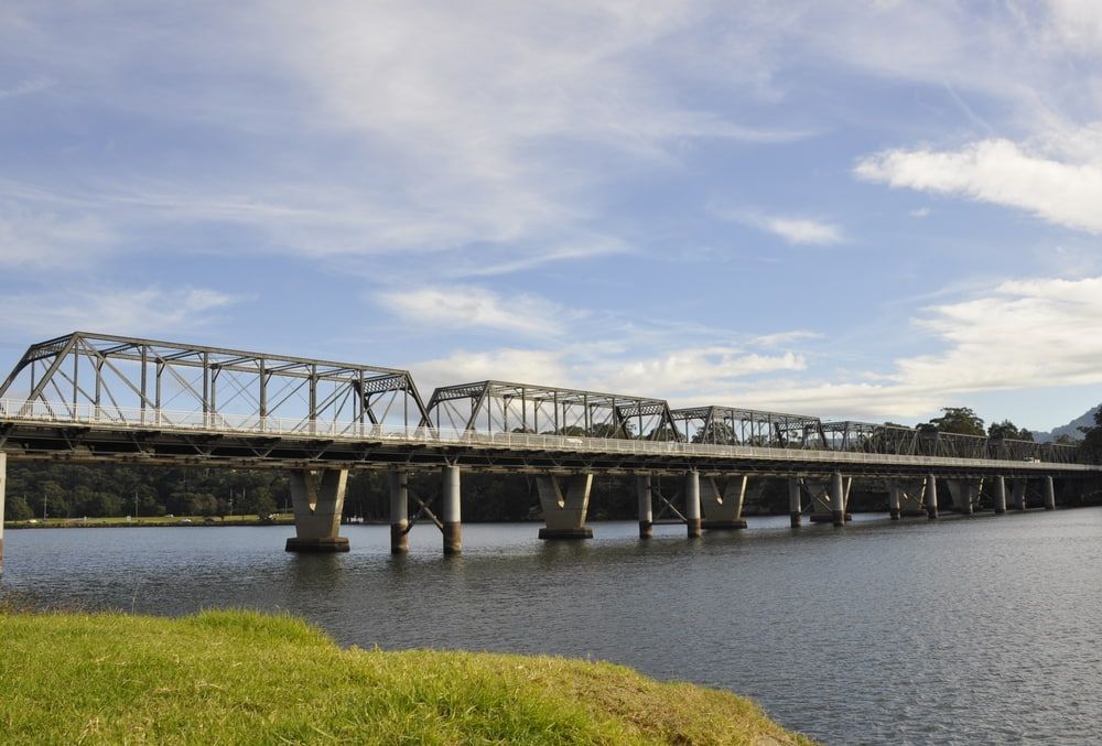 A Bridge Over a Body of Water with A Blue Sky in The Background — Parkes Machinery Services PTY LTD in Condo, NSW