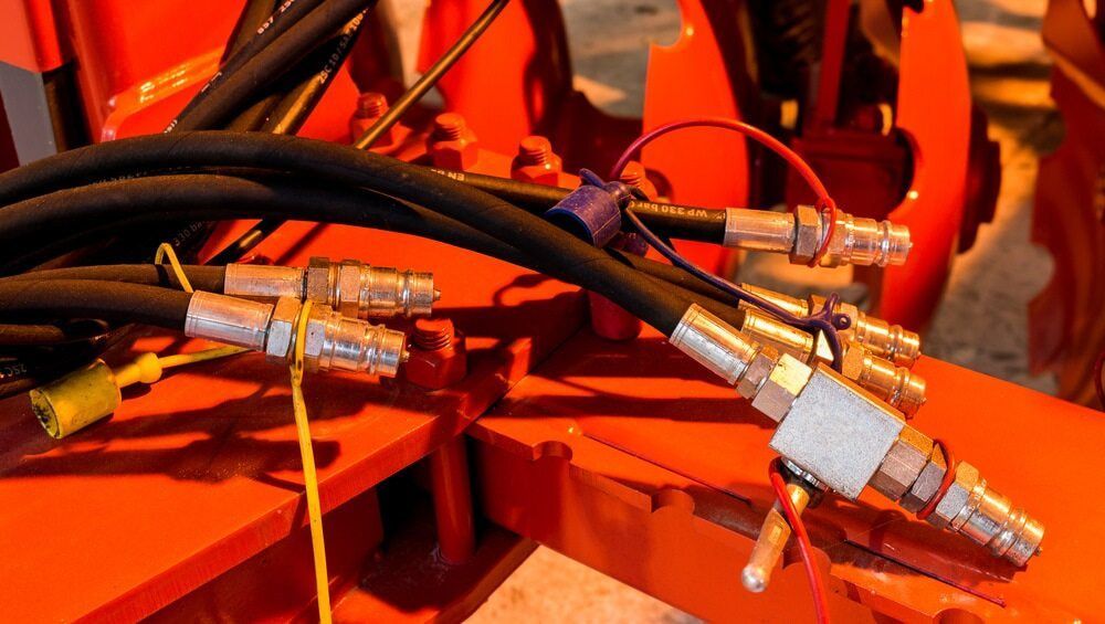 A Bunch of Hydraulic Hoses Are Connected to A Machine — Parkes Machinery Services PTY LTD in Parkes, NSW