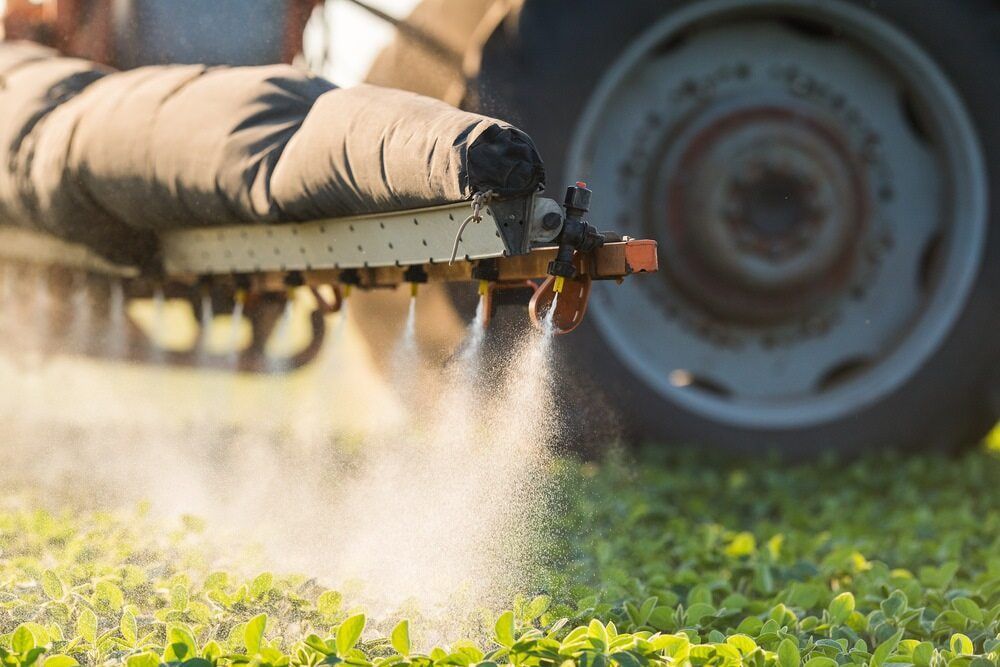 A Close Up of Tractor Spraying on Crops in Field — Parkes Machinery Services PTY LTD in Parkes, NSW