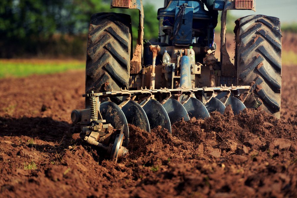 A Tractor Is Plowing a Field with Discs — Parkes Machinery Services PTY LTD in Warren, NSW