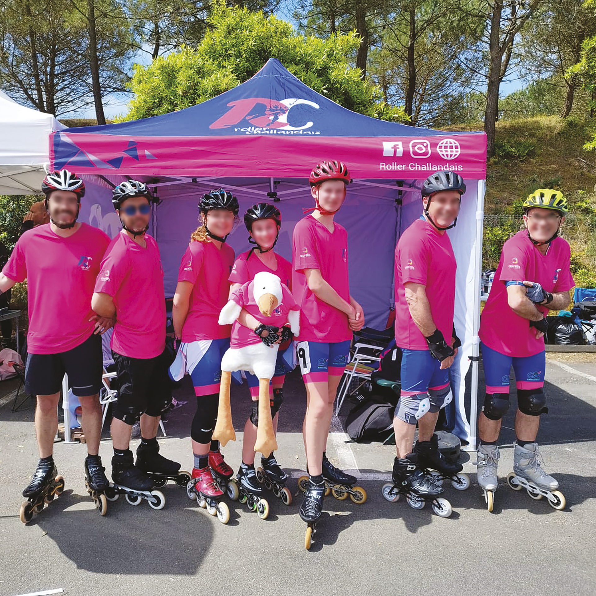 Un groupe de patineurs à roulettes en chemises roses et casques posent devant une tente.