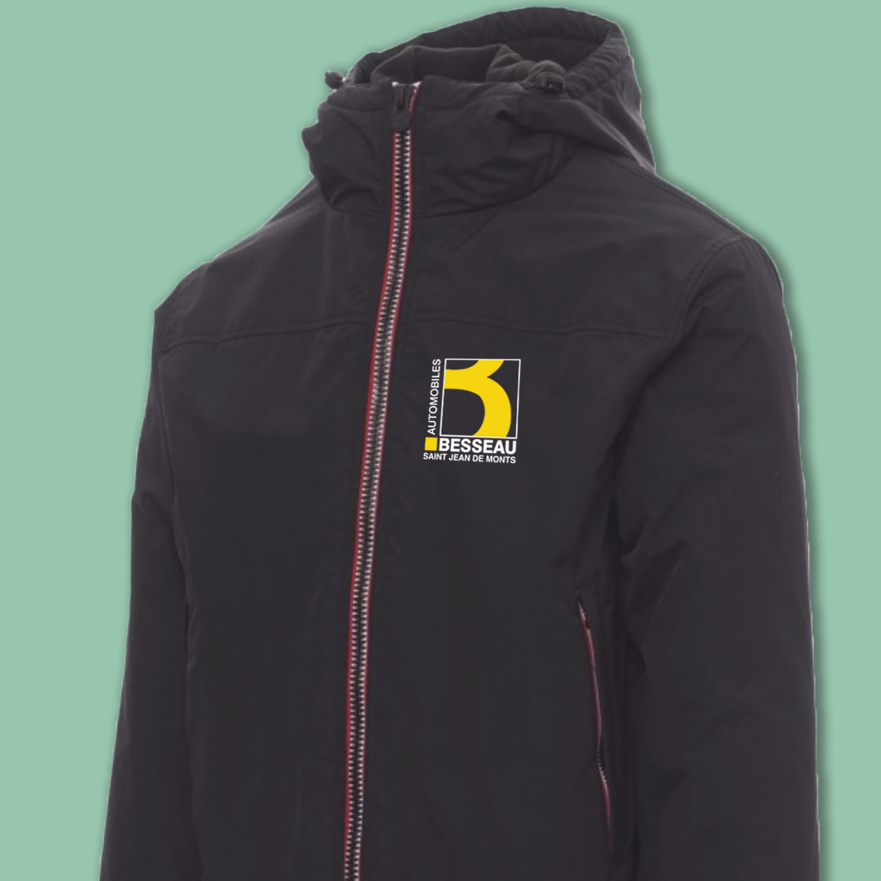 Veste noire avec capuche, logo jaune et noir sur la poitrine, détail de fermeture éclair rouge.