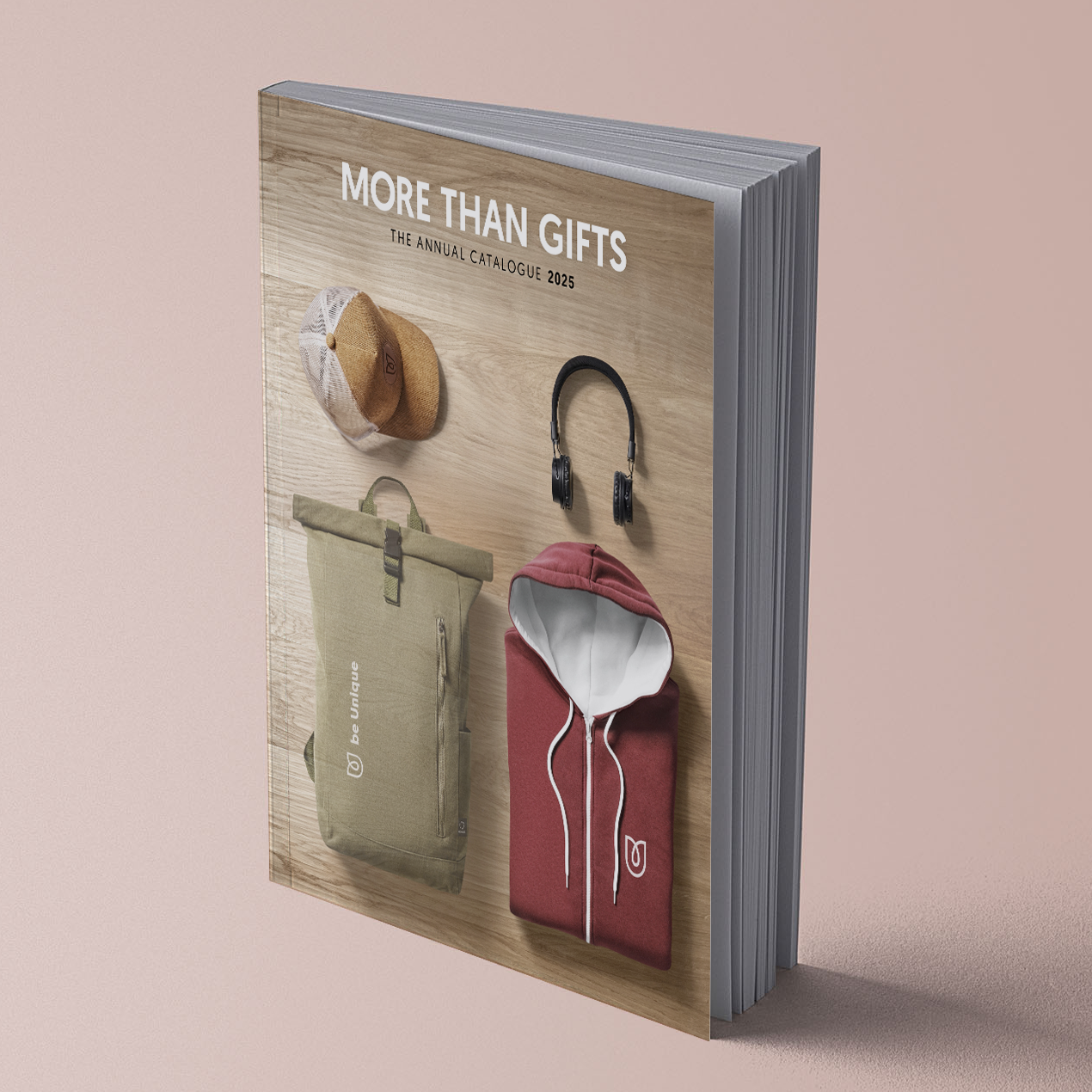 Couverture du catalogue représentant un chapeau, un casque audio, un sac à dos et un sweat à capuche sur fond boisé.