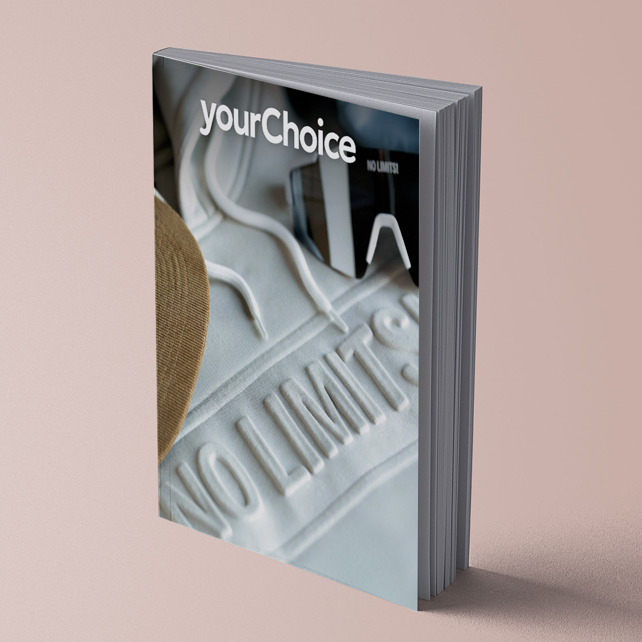 Un catalogue avec une couverture blanche, sur un fond rose clair.