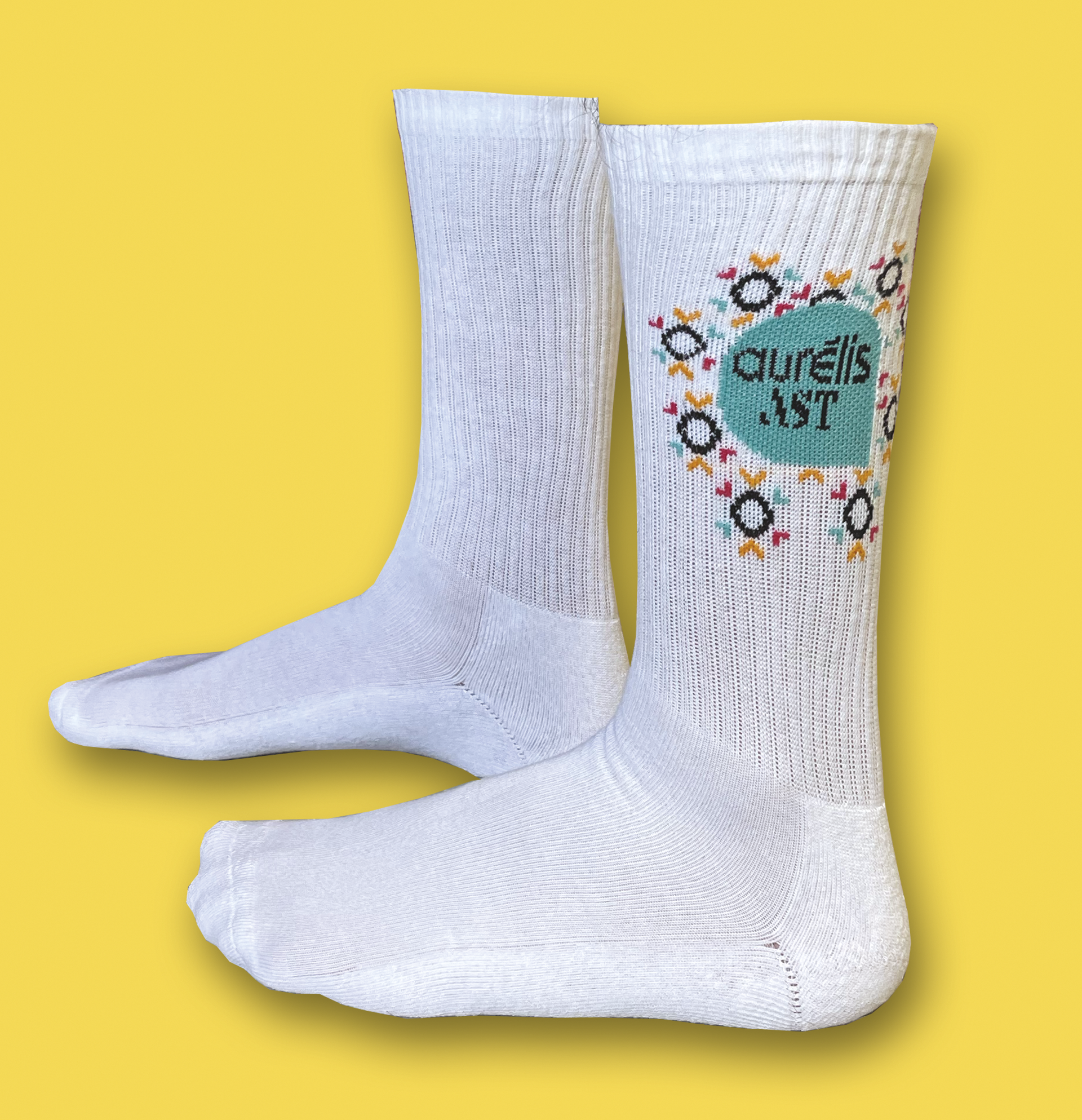 Chaussettes blanches avec un logo sur lequel on peut lire « Aureli's ART ». Fond jaune.