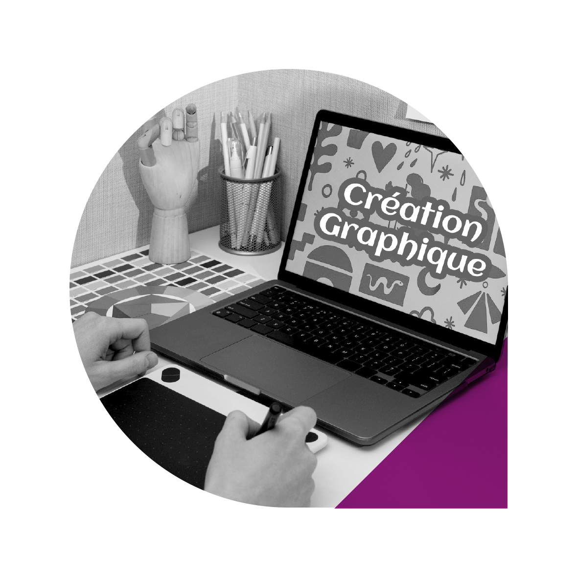 Une graphiste sur un ordinateur portable, avec une palette de couleurs et une tablette graphique