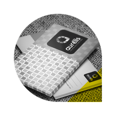 Une pile de supports marketing Aurelis présentant le logo, avec un motif à carreaux et un accent jaune.