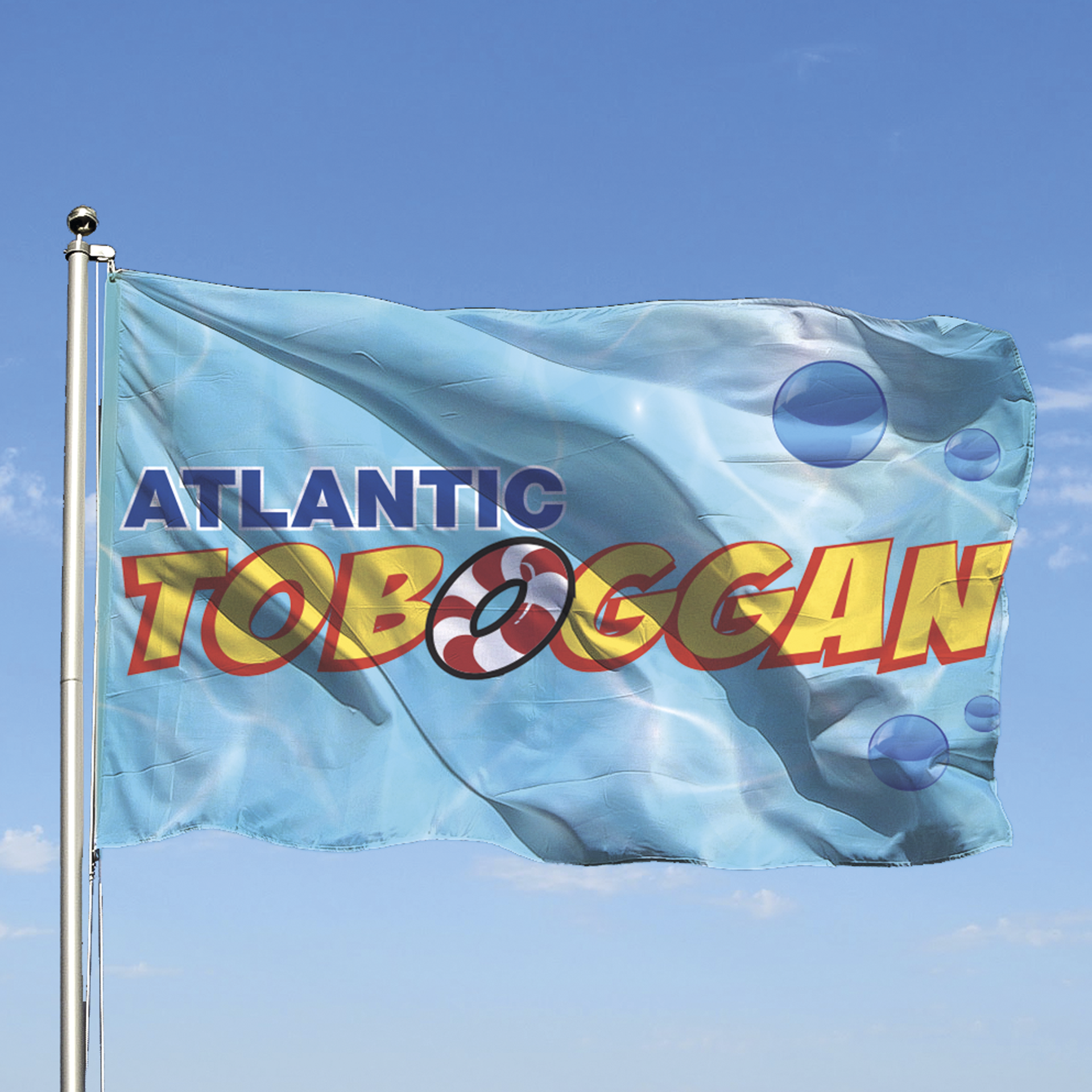 Drapeau du parc « Atlantic Toboggan » flottant au vent. Le drapeau arbore le logo et un motif sur le thème de l'eau.