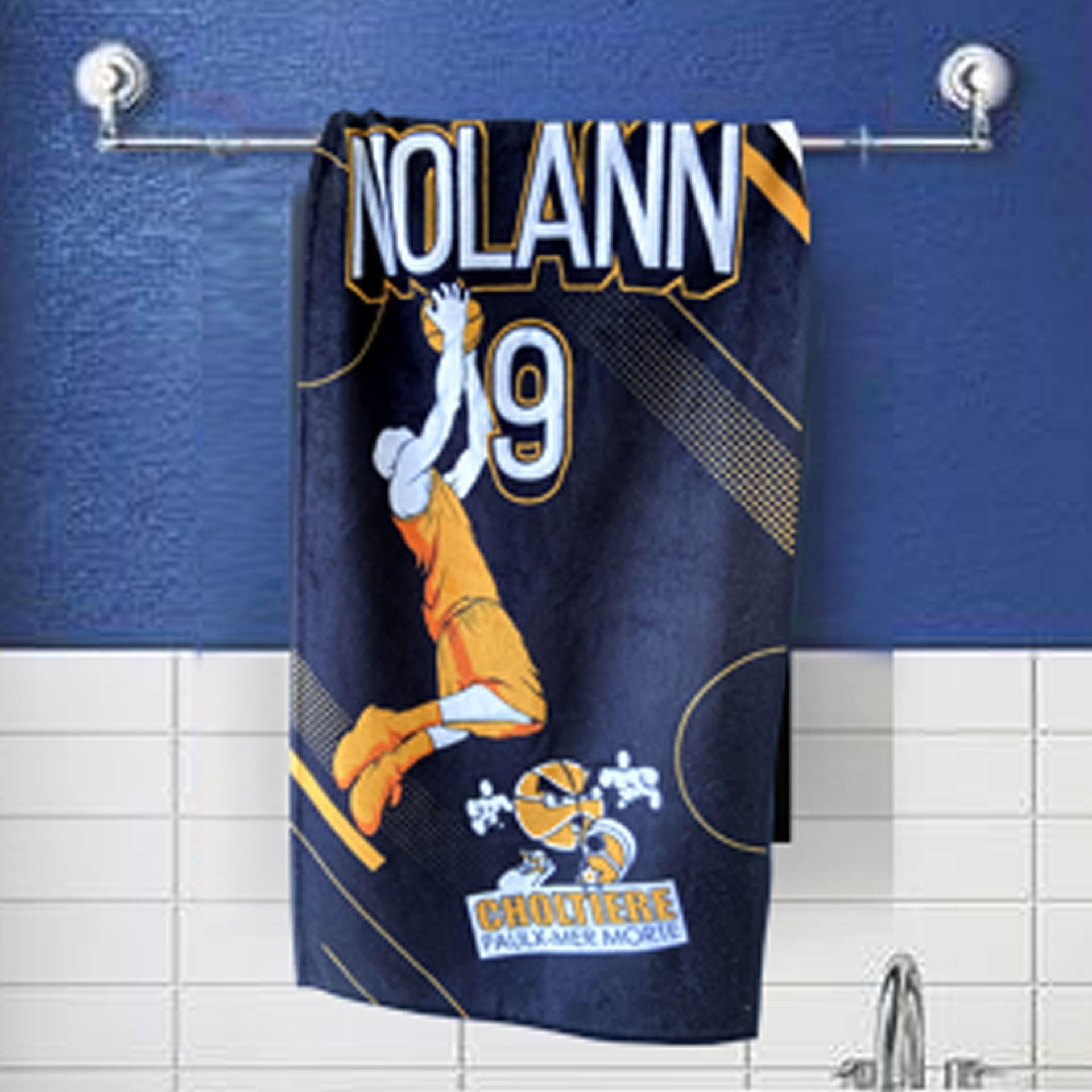 Serviette suspendue sur un support, représentant un joueur de basket en orange et blanc, sur un fond bleu.