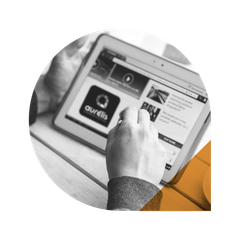 Personne utilisant une tablette avec le logo Aurelis visible, probablement en train de naviguer sur un site web.
