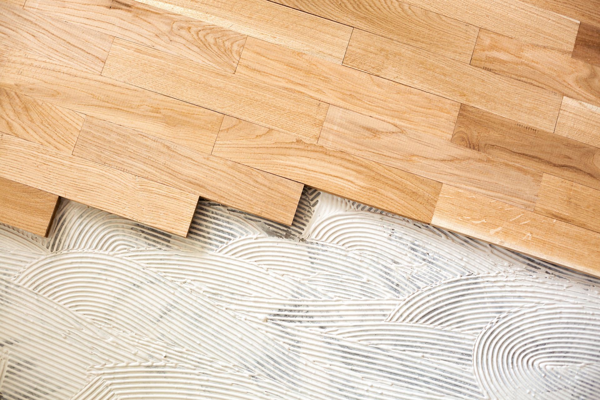 A wooden floor is being installed on a tile floor.