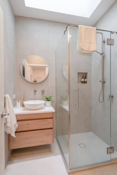 A bathroom with a sink , mirror , and walk in shower.