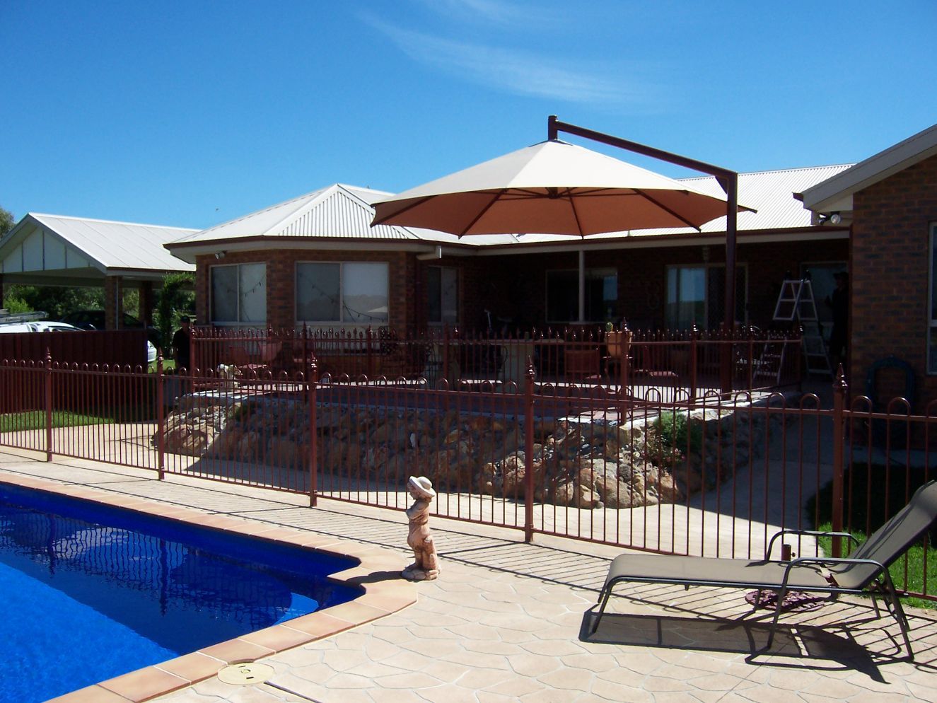 Brown Cantilever Umbrella Covering The Pool — Outdoor Umbrellas in Albury, NSW