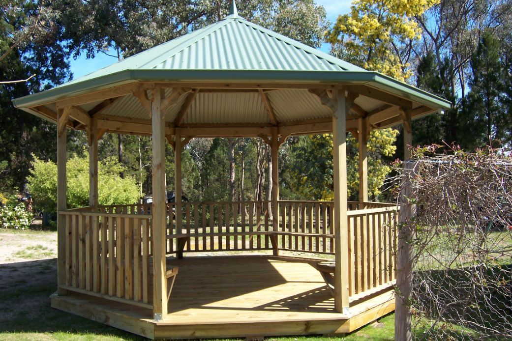 A Wooden Gazebo With A Green Roof Is Sitting In The Middle Of A Park - Gazebos in Albury, QLD