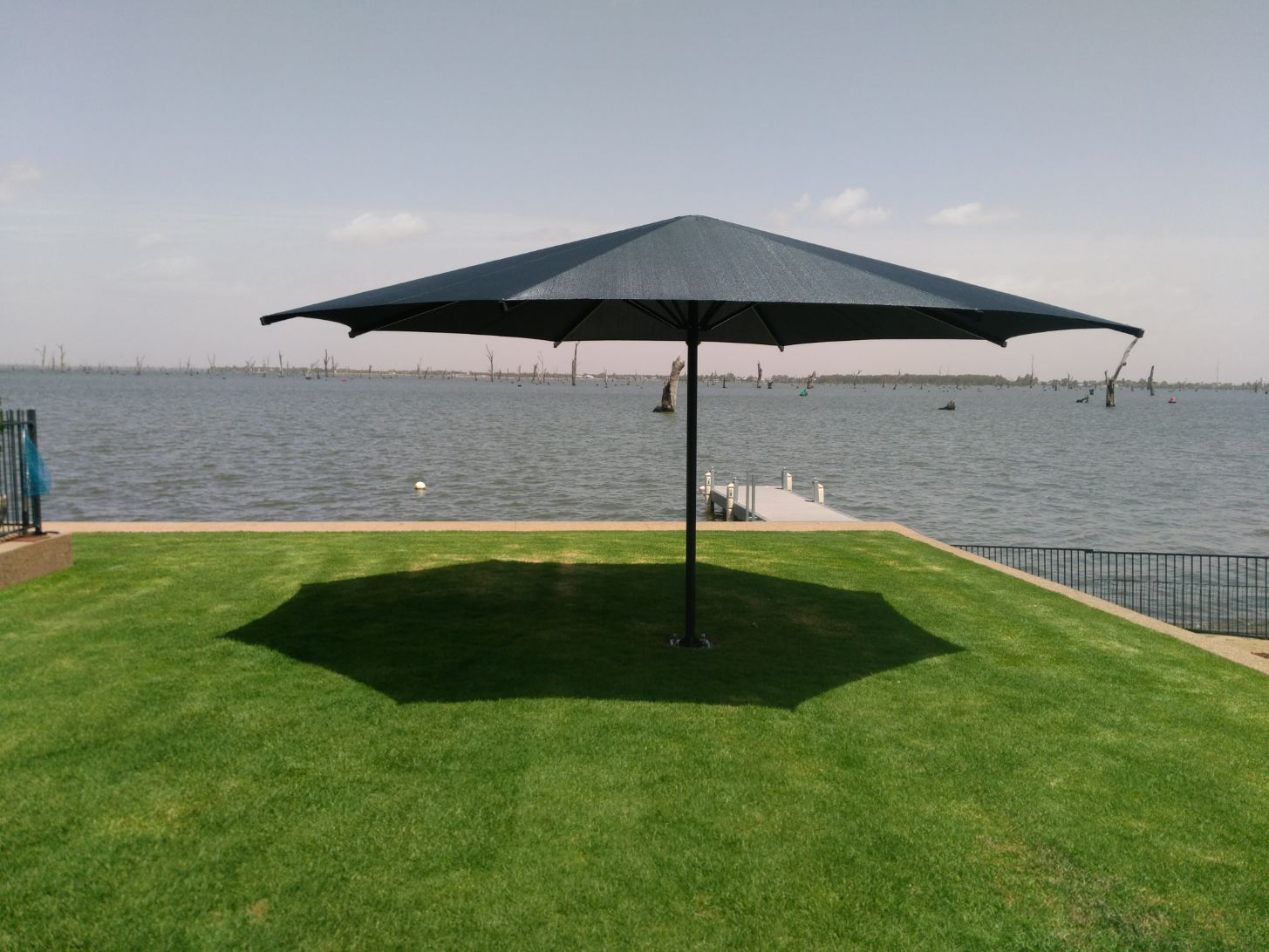 Black Centre Pole Umbrella On A Grass Field — Custom Blinds in Bright, NSW