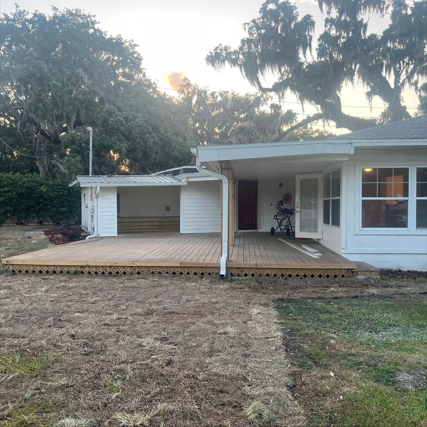 White house with a wooden deck and a ramp, wheelchair accessible.