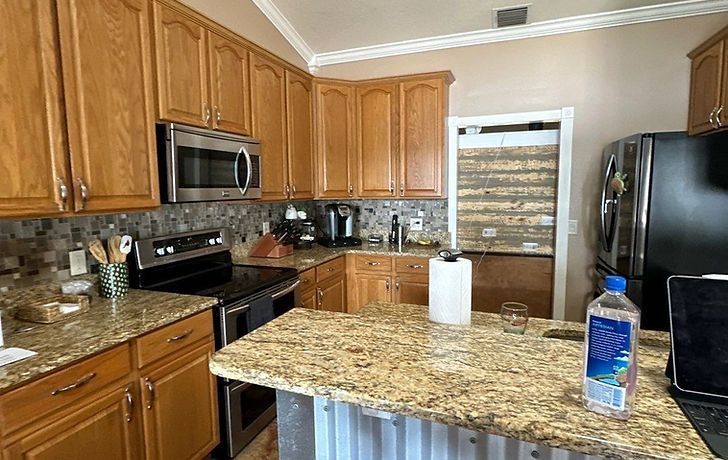 Kitchen with wooden cabinets, granite countertops, and stainless steel appliances.