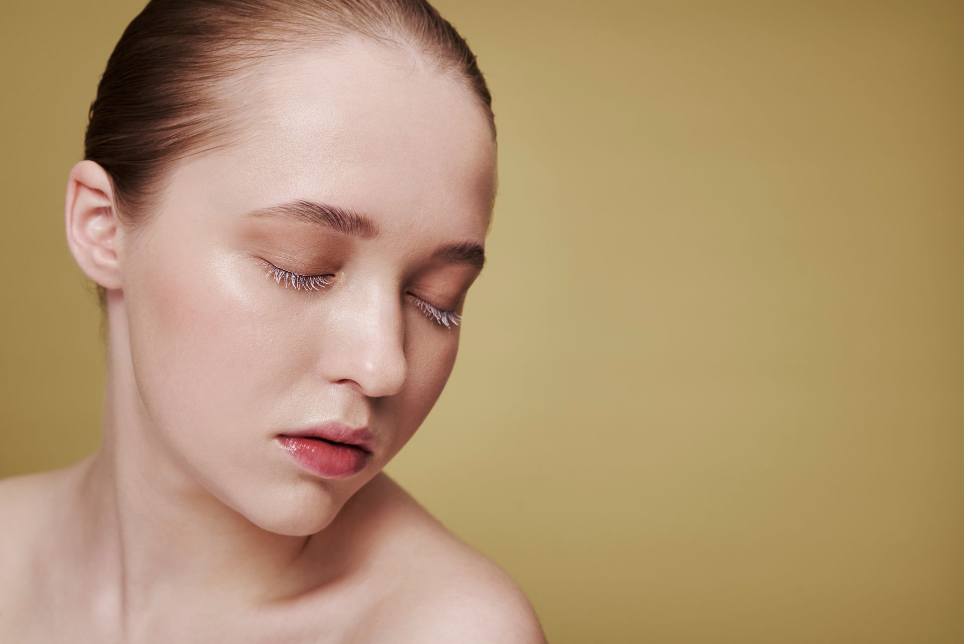 A close up of a woman 's face with her eyes closed.