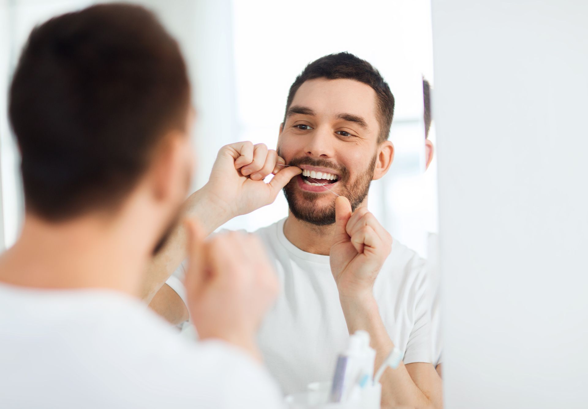 a man is brushing his teeth in front of a mirror .