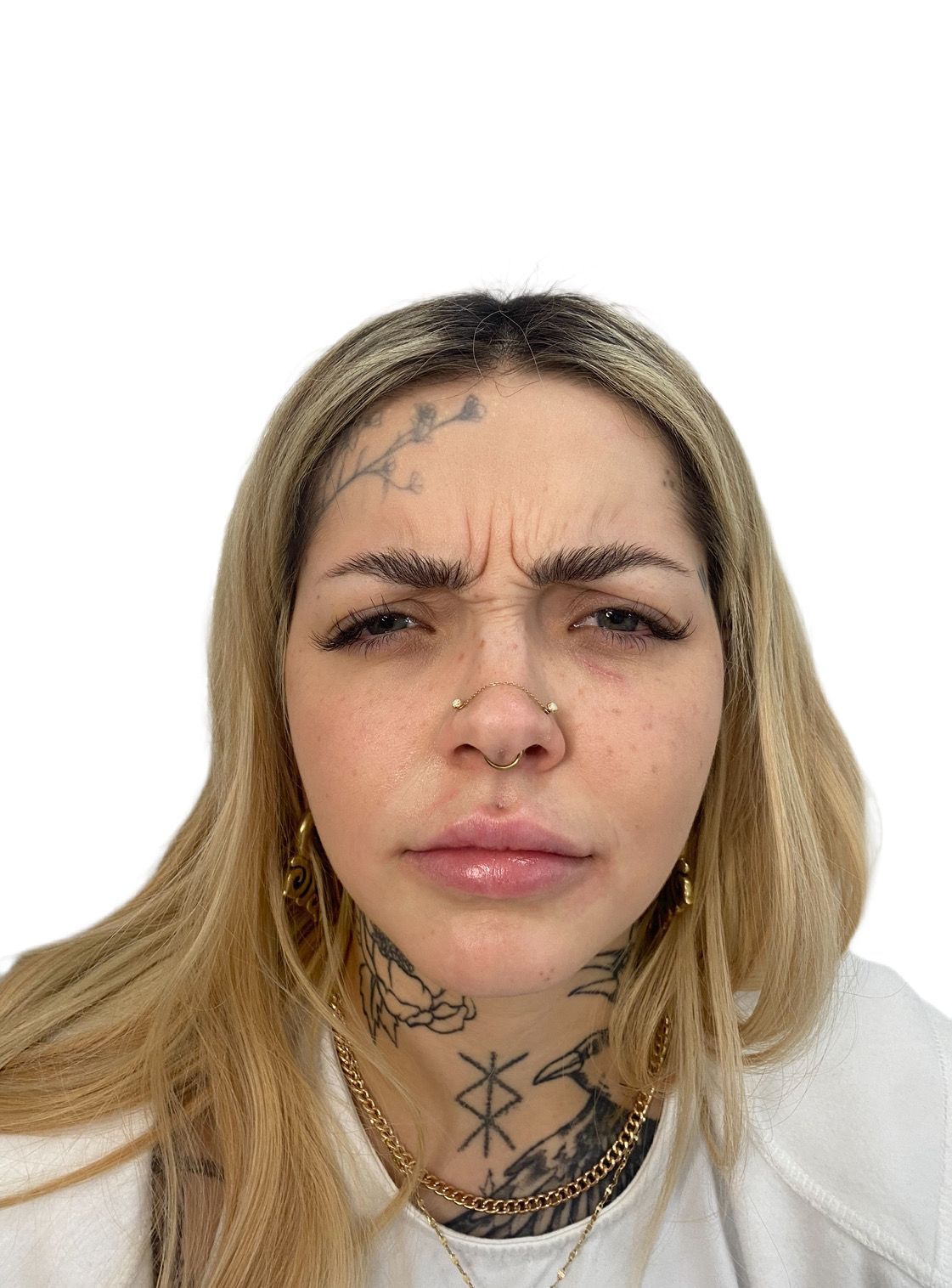 A woman with tattoos on her face is making a funny face.