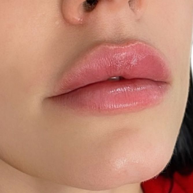 A close up of a woman 's lips with pink lipstick.