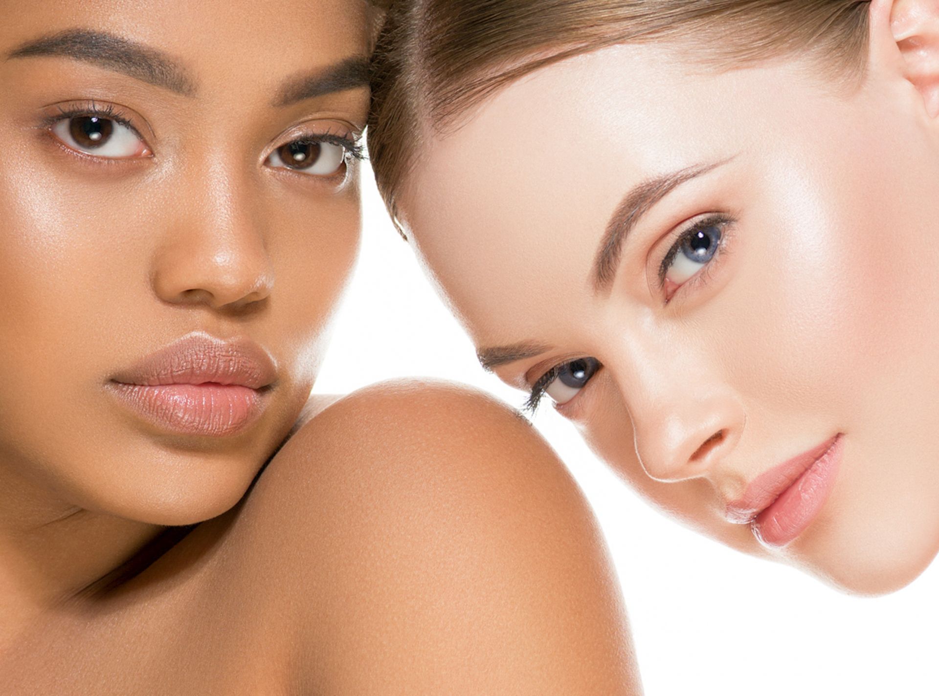 Two women with different skin tones are looking at the camera.