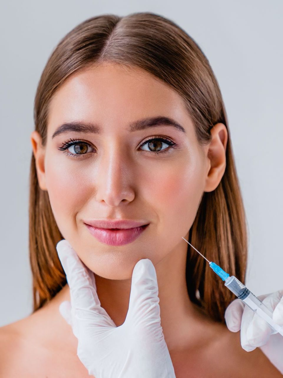 A woman is getting a botox injection in her face.